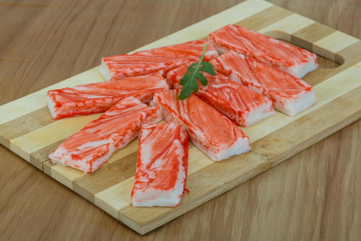 Crab sticks on wooden board and wooden background photo