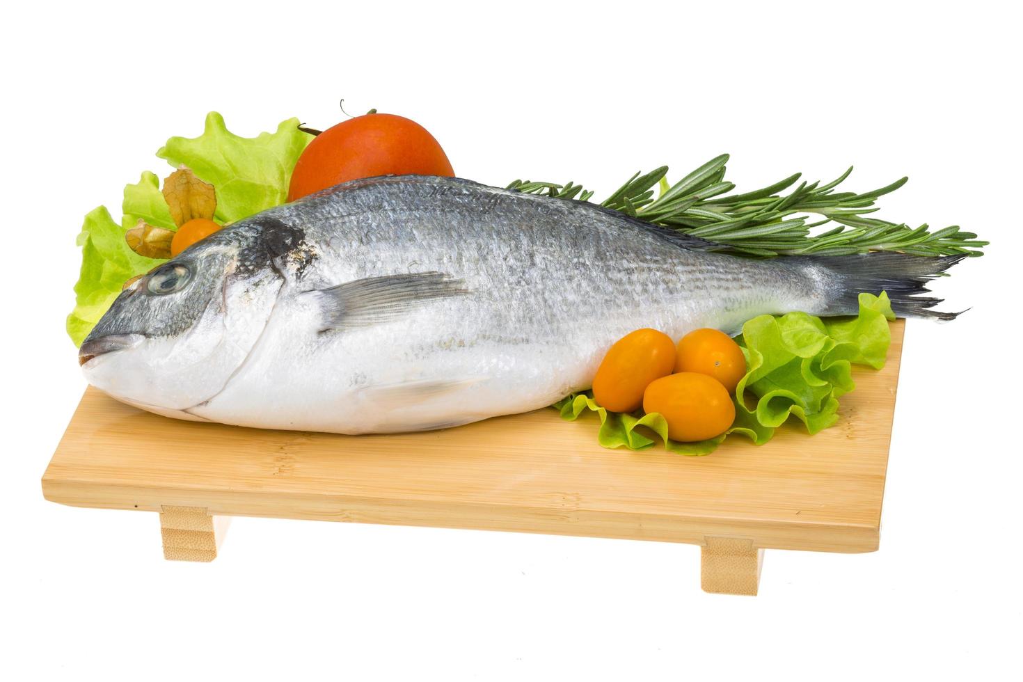 Raw dorado on wooden board and white background photo