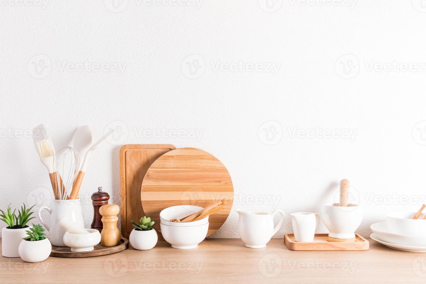 various types of kitchen utensils on a wooden countertop at the textured white concrete wall. Zero waste,environmentally friendly concept. photo