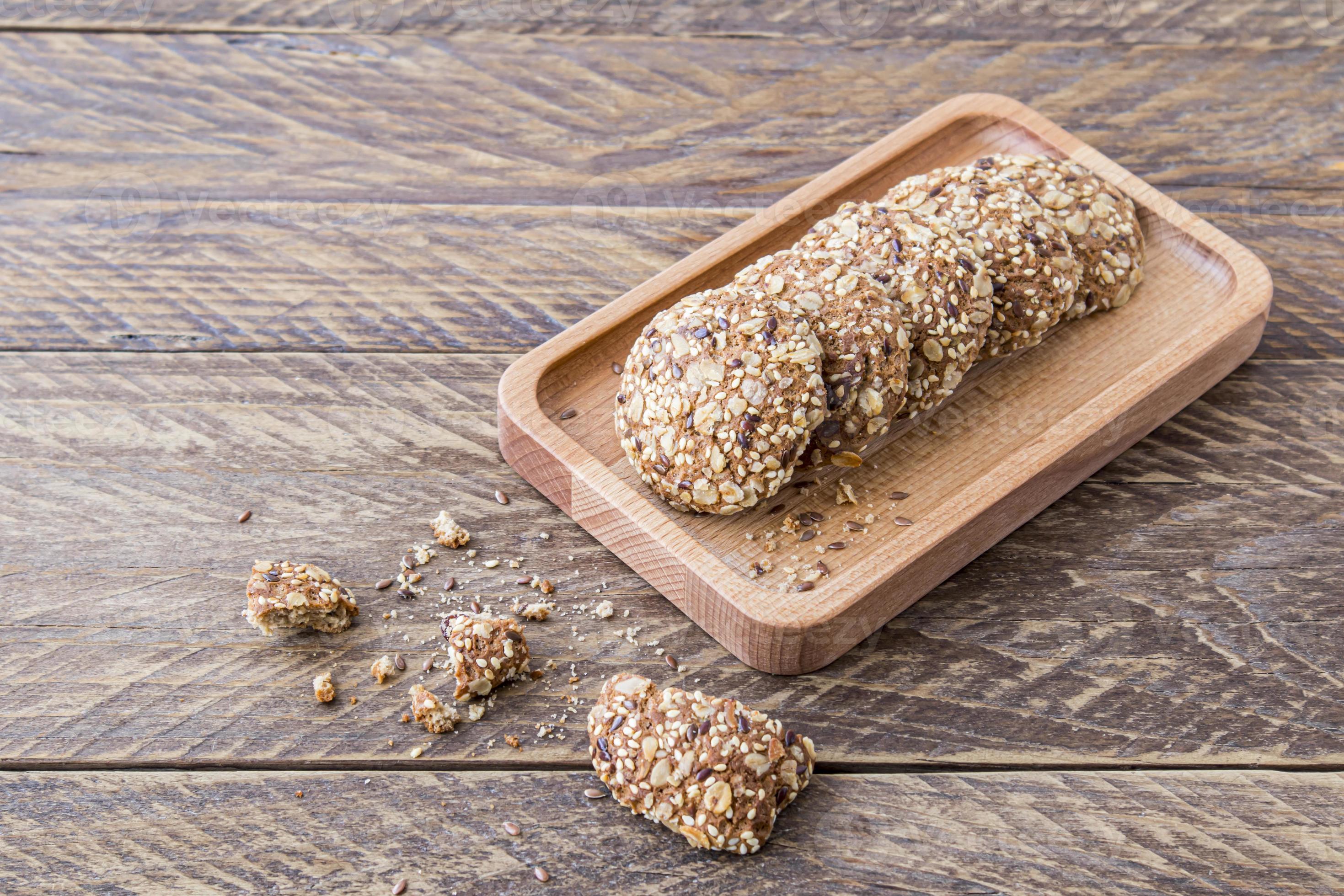 homemade oatmeal biscuits with various cereals are laid out on a wooden