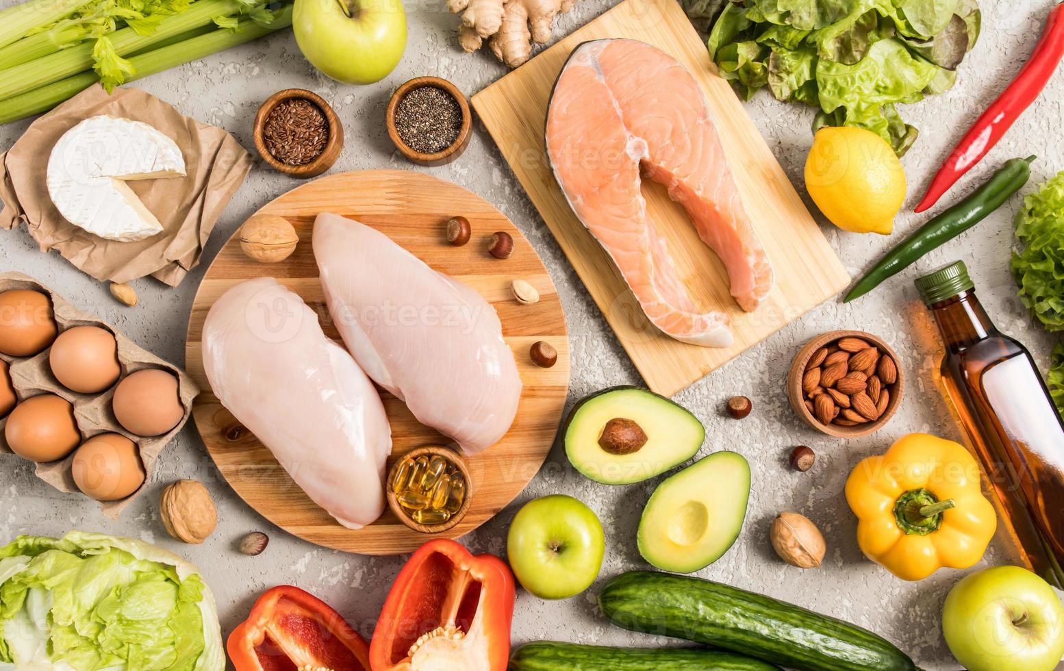 flat composition with useful products containing unsaturated fatty acids. omega 3, salmon steak, avocado, nuts, eggs. gray background. photo