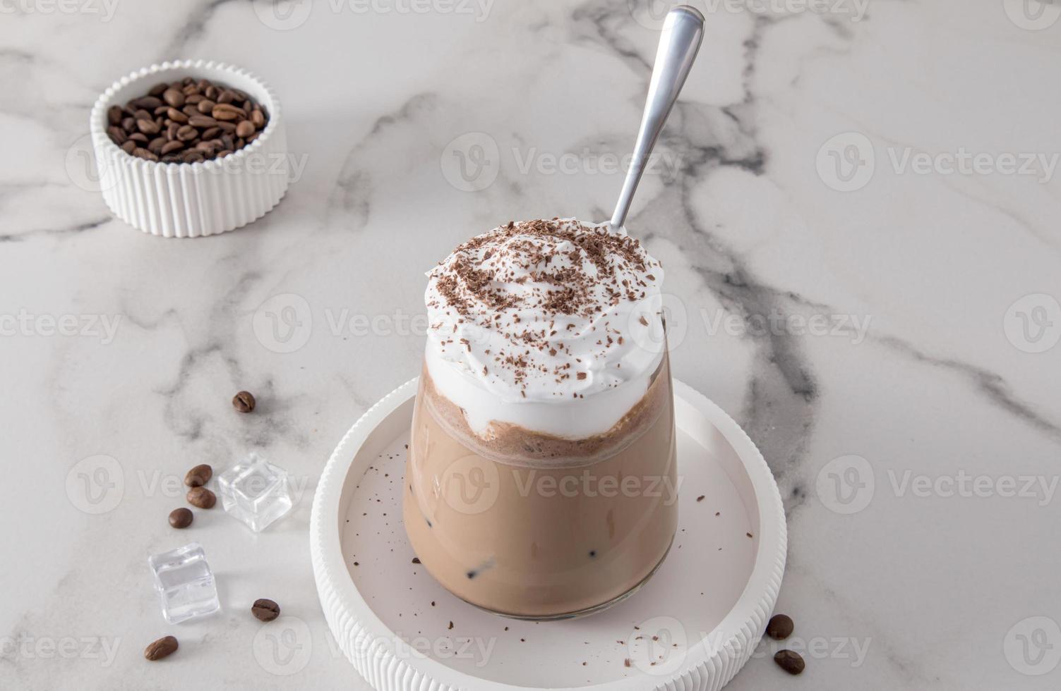 a large glass of coffe latte or cappuccino with milk and whipped cream or ice cream. delicious summer dessert in hot weather. photo