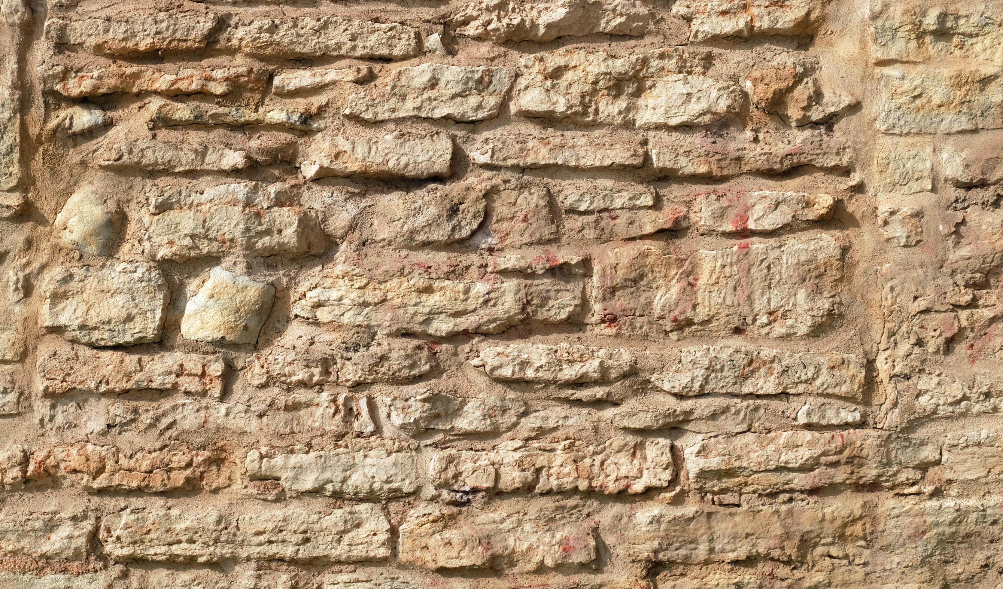 textura de una pared de piedra beige. superficie lisa y agrietada