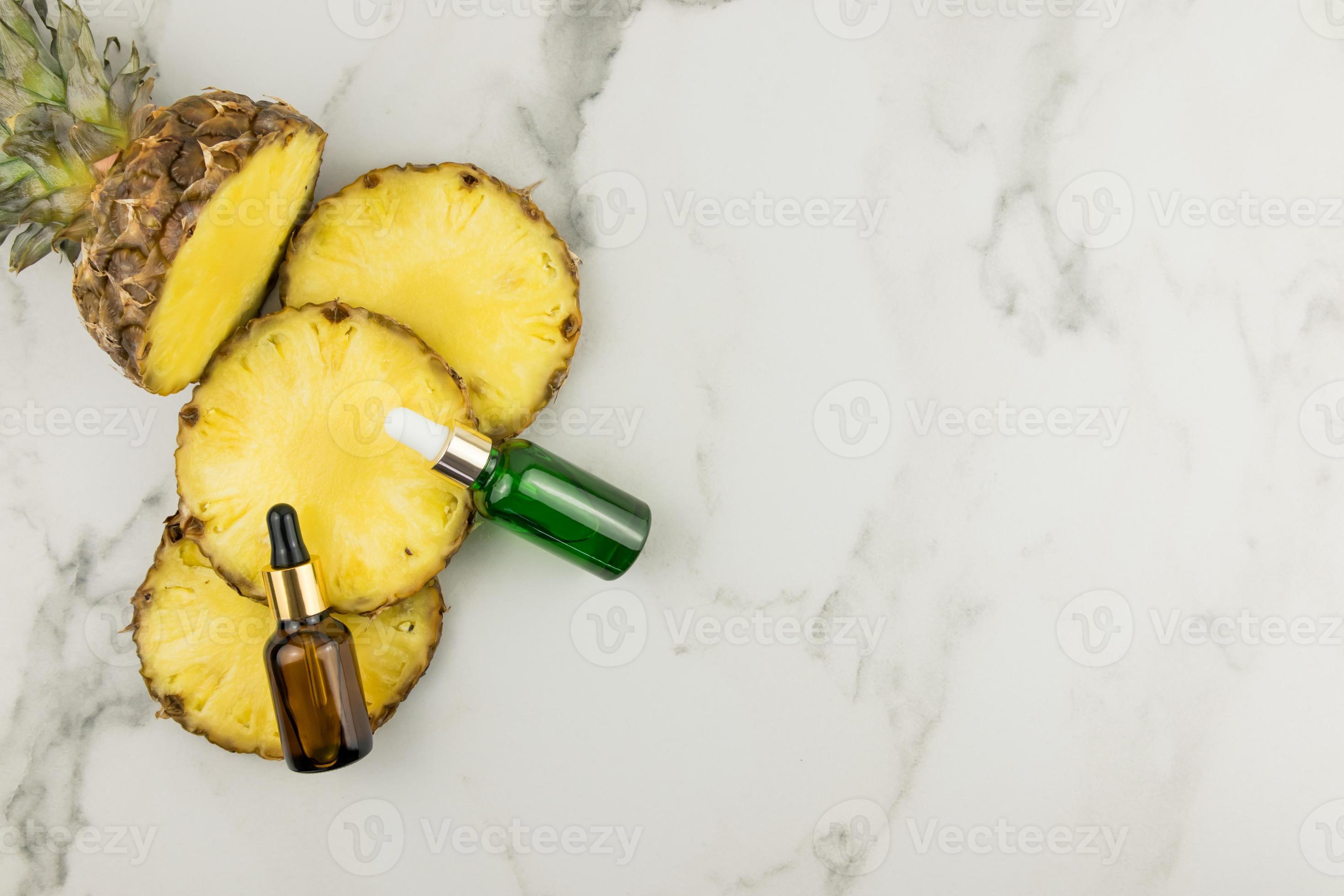 face serum with pineapple extract in cosmetic bottles on slices of