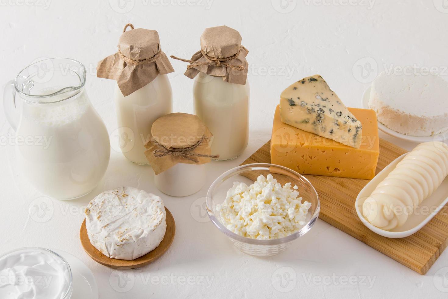 fresh dairy homemade natural products for daily consumption. milk, cottage cheese, cheese, yogurt in various dishes on a white background. photo