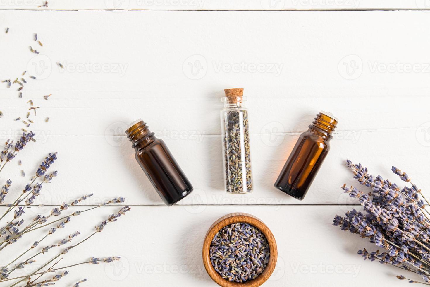 el concepto de un aceite esencial de lavanda orgánico natural para el cuidado personal. tratamientos de spa, aromaterapia, relajación. vista superior. fondo de madera blanca. foto