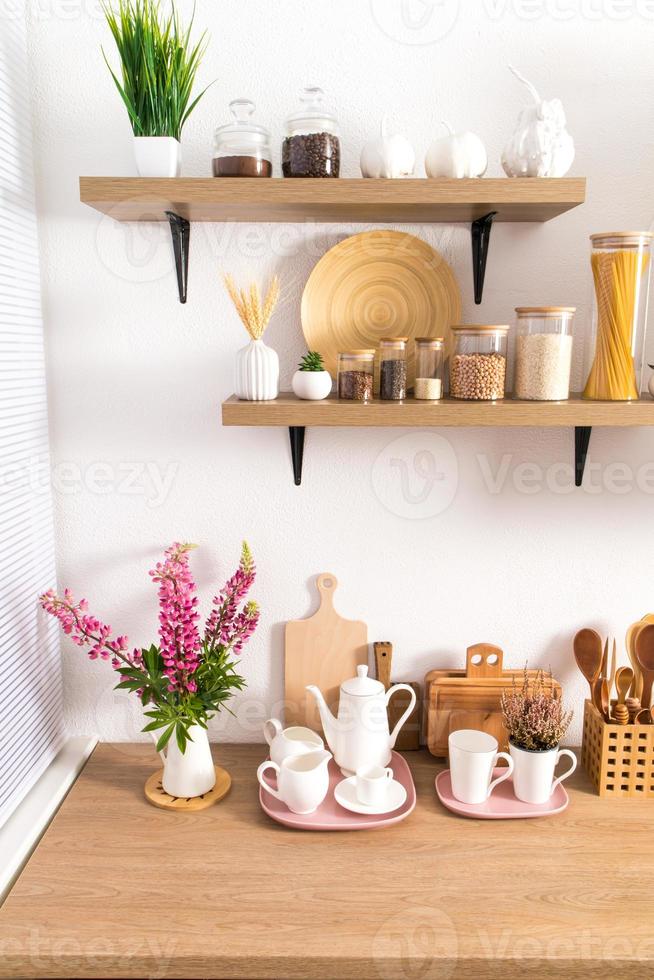 part of the interior of the modern kitchen . open shelves with various jars and countertop with kitchen utensils. ecologically clean kitchen. photo