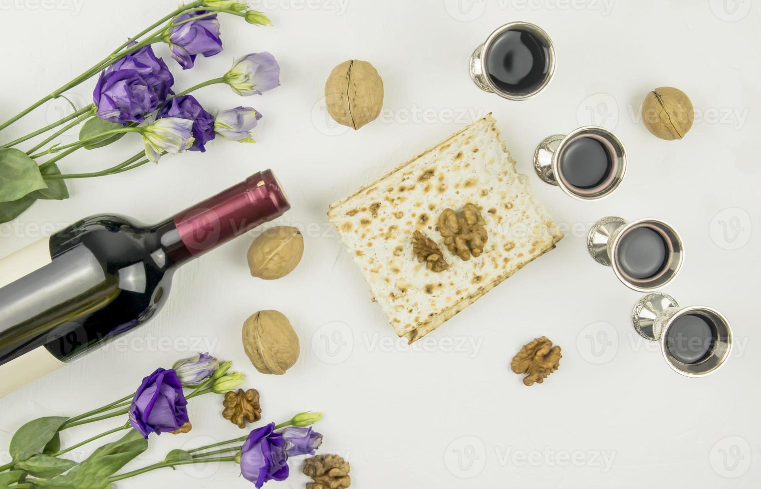 el concepto de la fiesta de pascua. pesah. vista superior de matzá, copas de plata con vino tinto, una botella de vino, nueces. foto