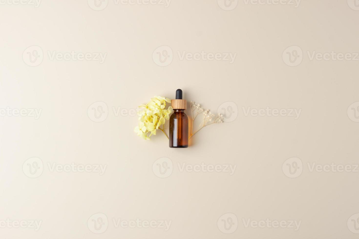 botella cosmética con flores sobre fondo beige pastel. endecha plana, espacio de copia foto