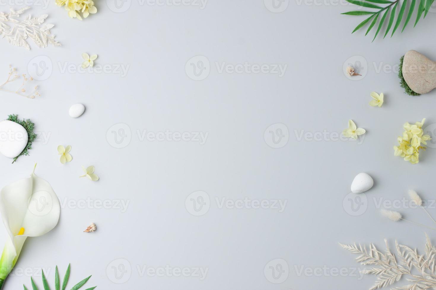 Cosmetic background with flowers, moss and stone on grey. Flat lay, copy space photo