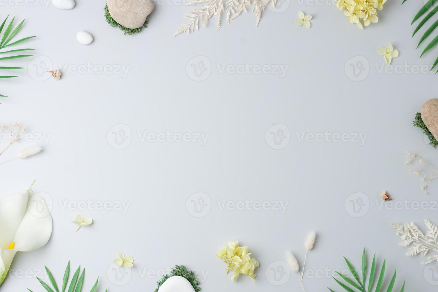 Cosmetic background with flowers, moss and stone on grey. Flat lay, copy space photo