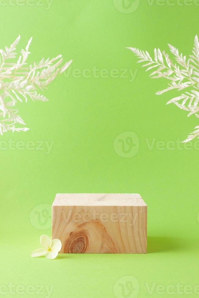 Cosmetic background with wood podium and flowers on green. Empty showcase for cosmetic product presentation. on green background. Close up, copy space photo