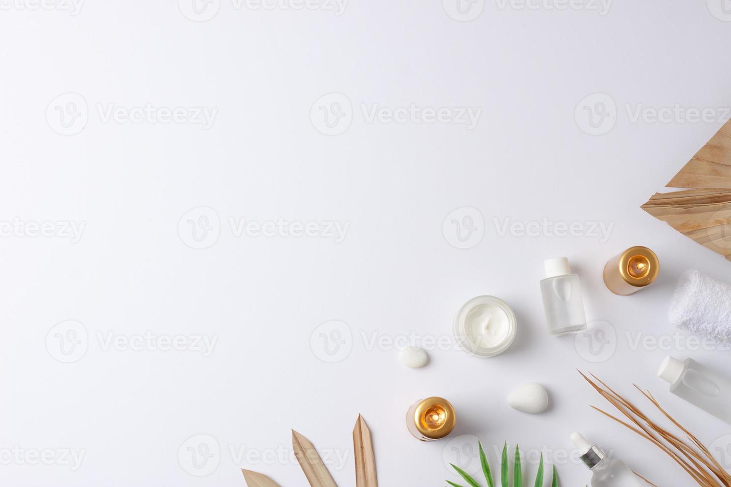 Spa treatment with cosmetic bottle, candles and palm leaf on white background. Flat lay, copy space photo