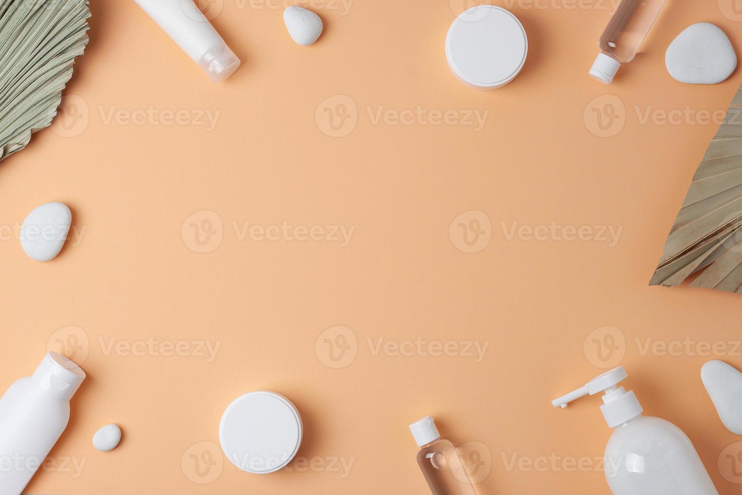 Cosmetic skin care products with palm leaf on pastel beige background. Flat lay, copy space photo