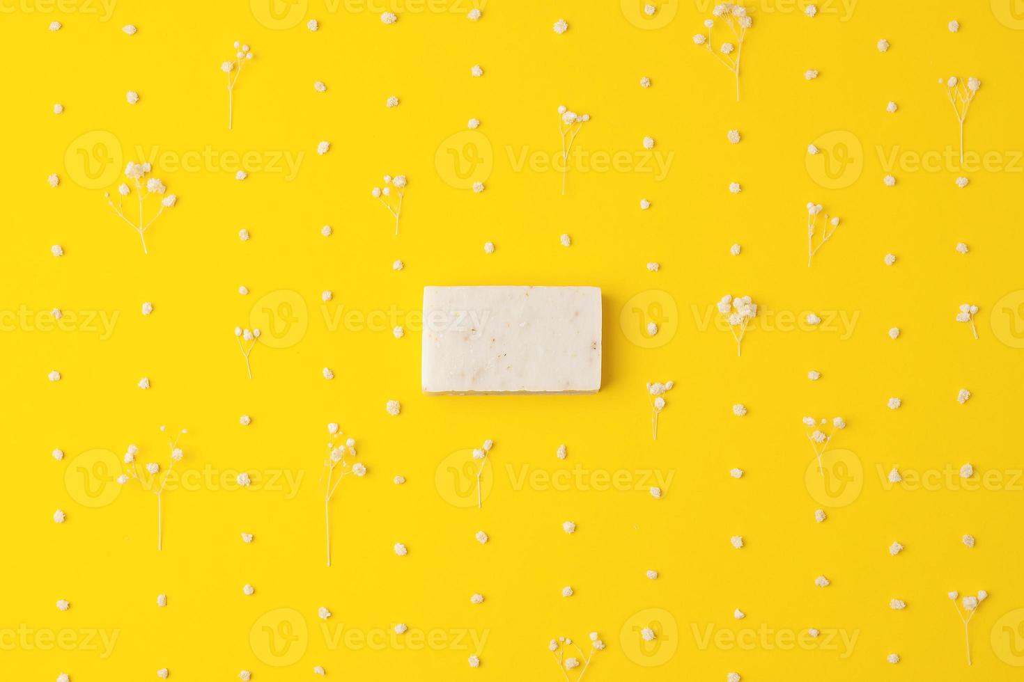Soap and flower on yellow background. Flat lay, copy space. photo
