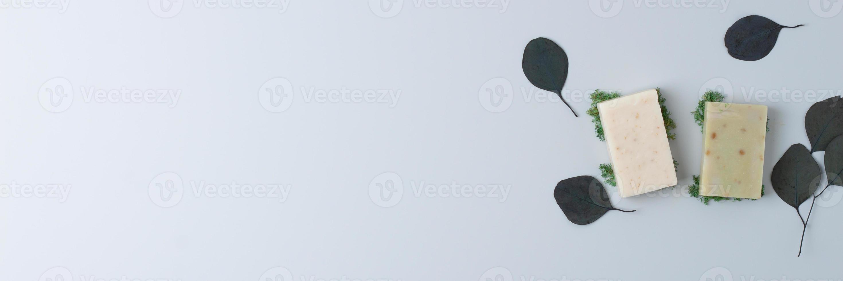Soap and flower on grey background. Flat lay, copy space. photo