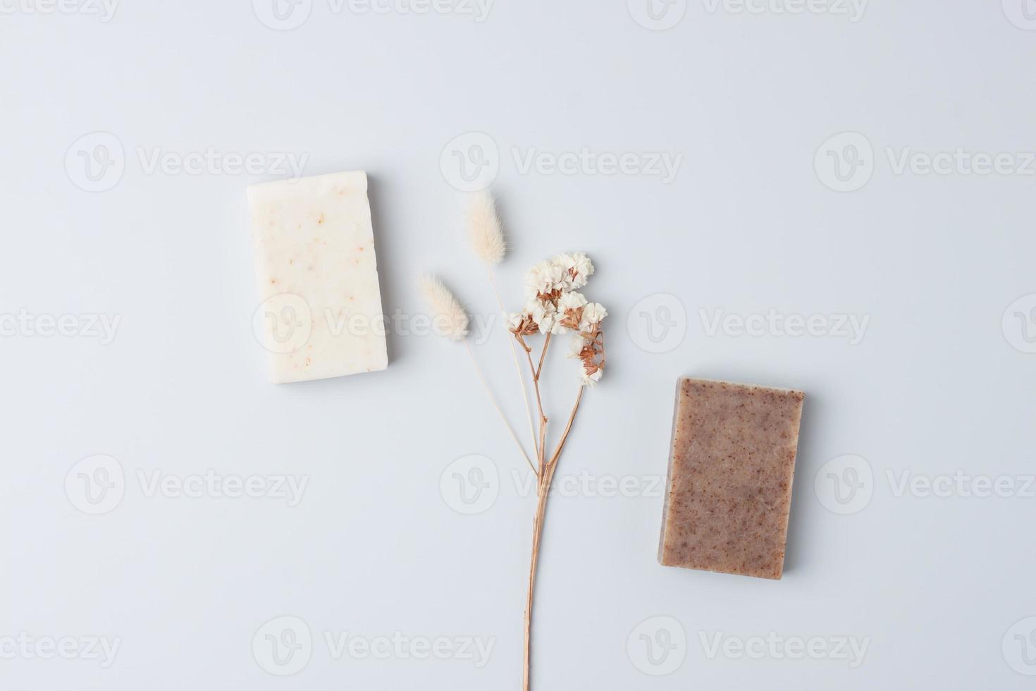 Soap with flowers on grey background. Flat lay, copy space. photo