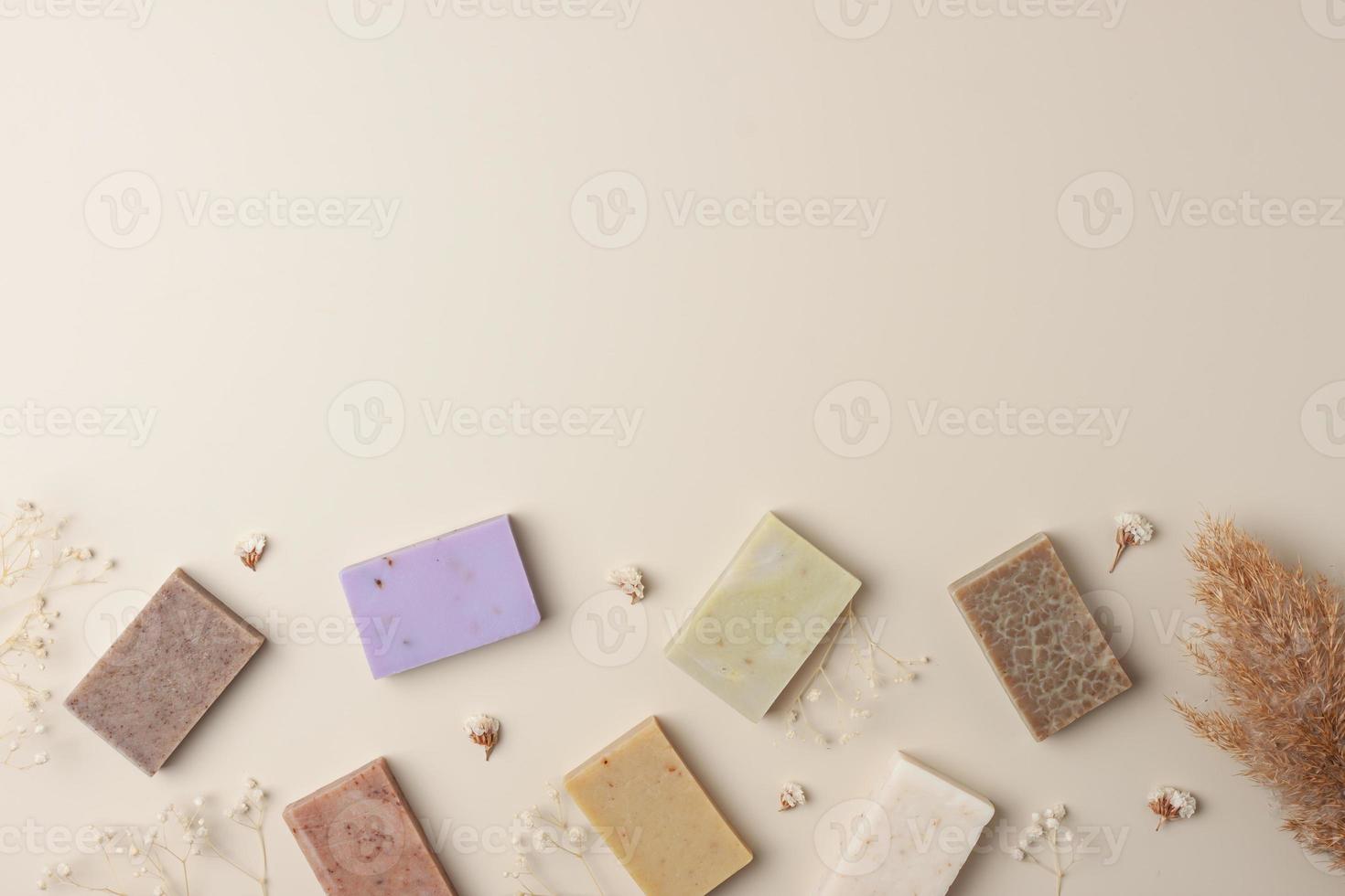 Soap and flower on beige background. Flat lay, copy space. photo