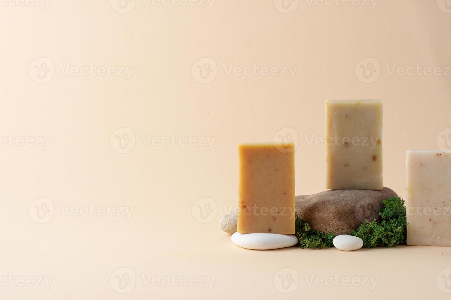 Soap with moss and stone on beige background. Close up, copy space. photo