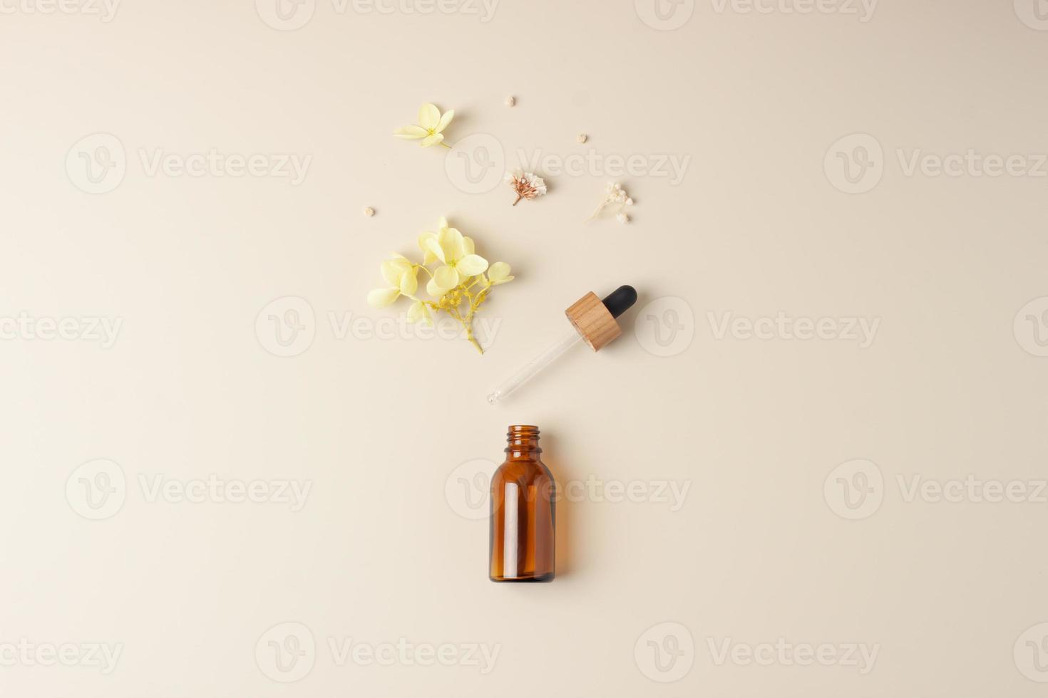 Minimal composition with cosmetic bottle with flowers on pastel beige background. Flat lay, copy space photo