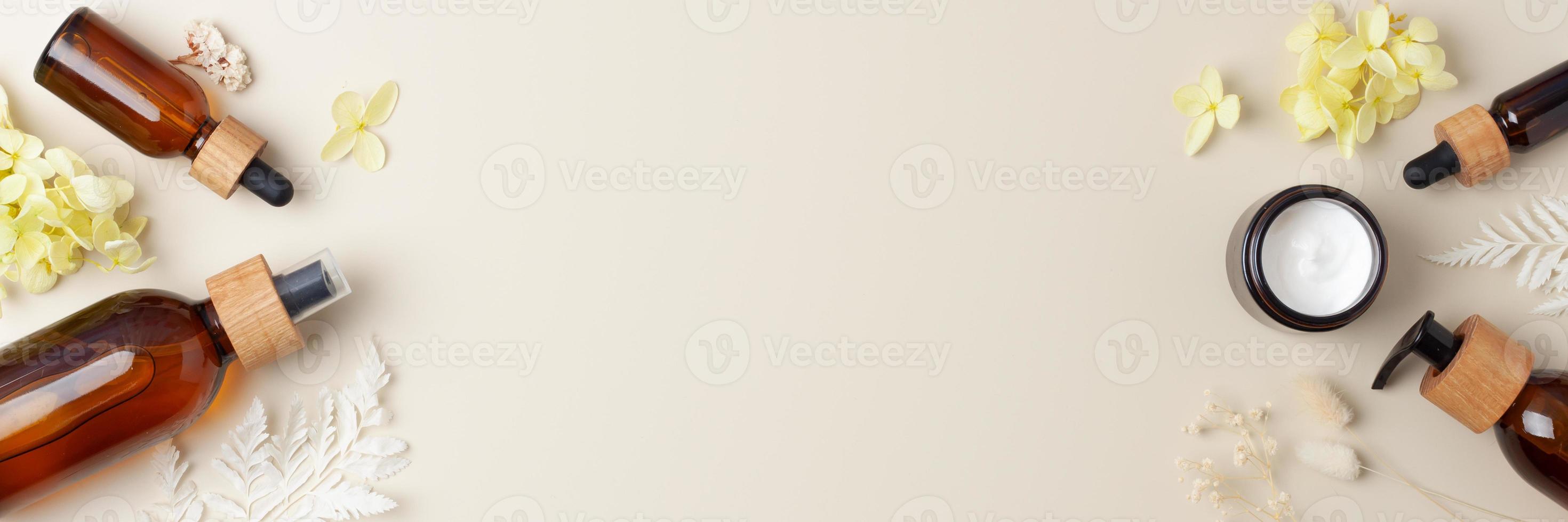 Cosmetic skin care products with flowers on pastel beige background. Flat lay, copy space photo