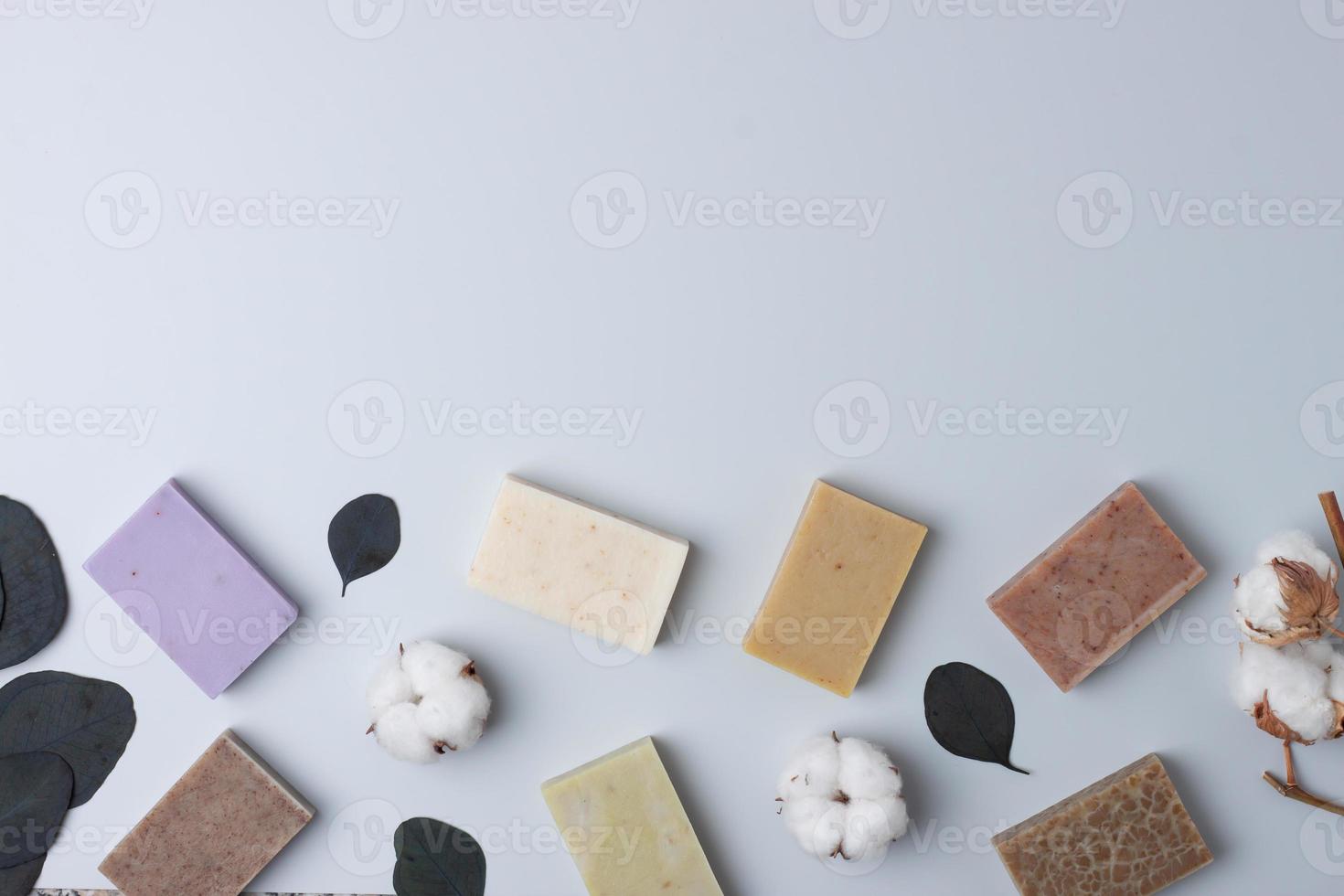 Soap and flower on grey background. Flat lay, copy space. photo