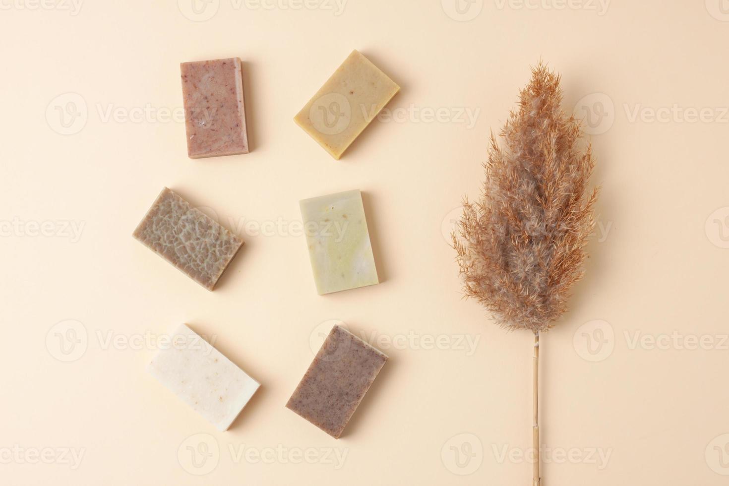 Soap with flowers on pastel beige background. Flat lay, copy space. photo