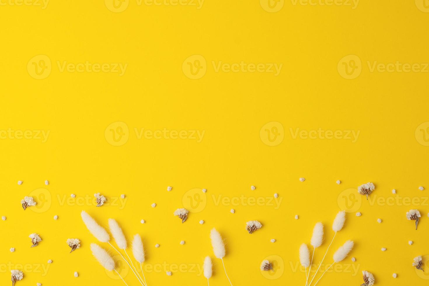Cosmetic background with flowers on yellow. Flat lay, copy space photo