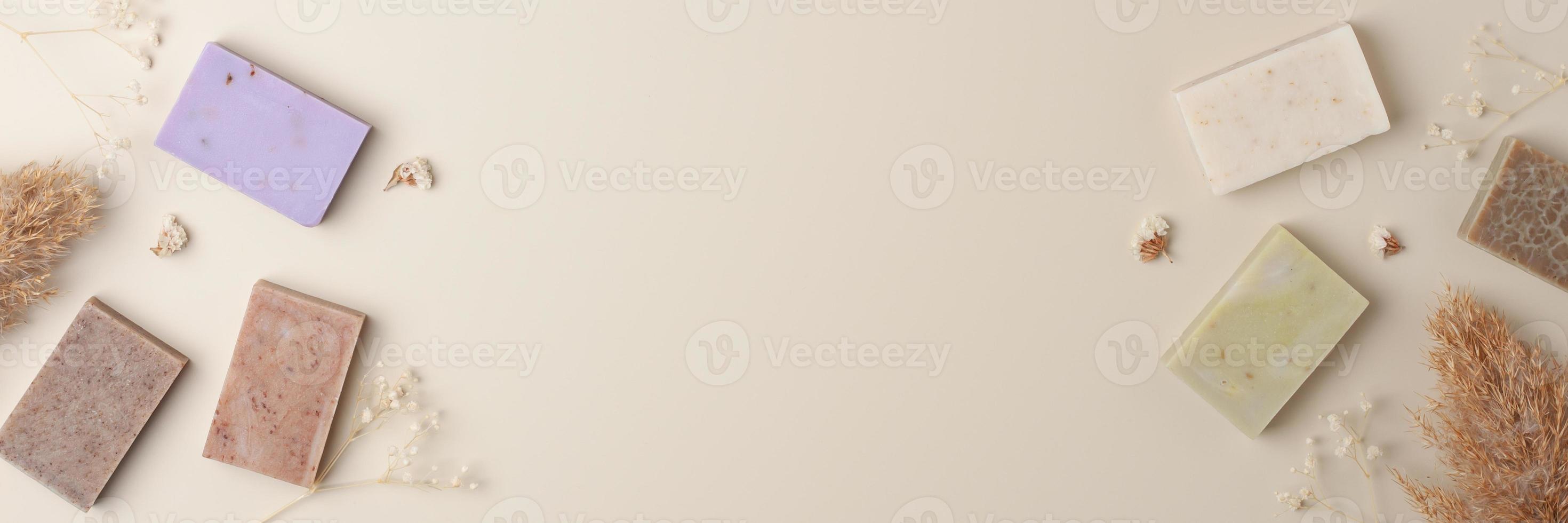 Soap and flower on beige background. Flat lay, copy space. photo