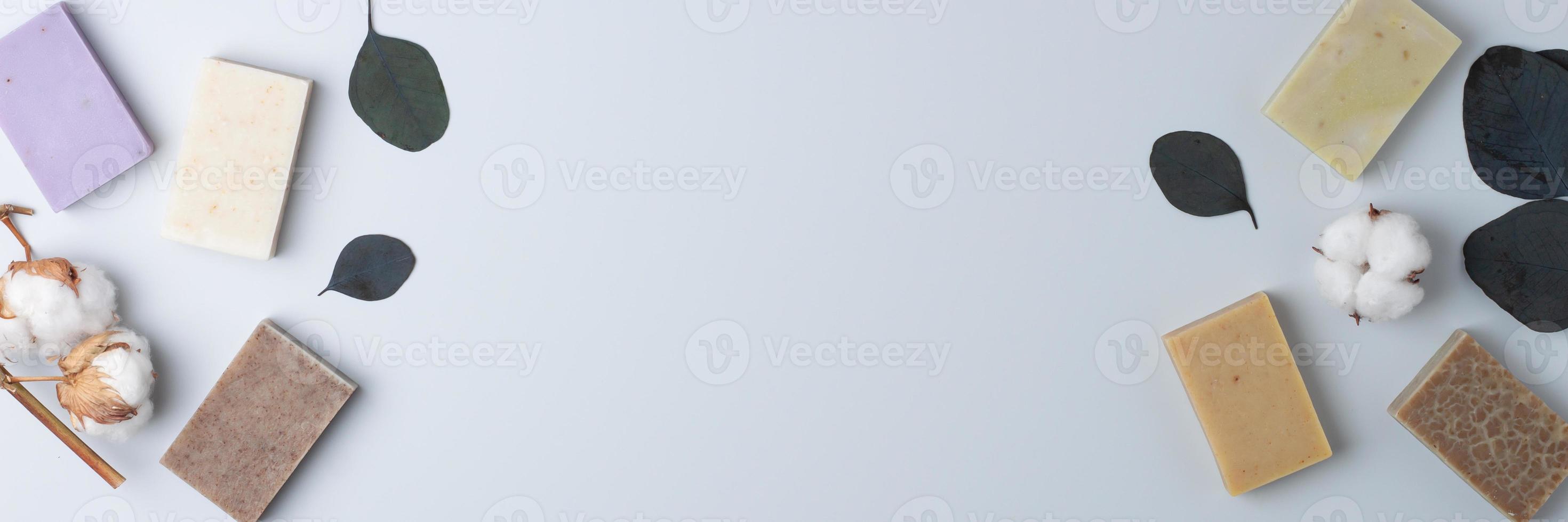 Soap and flower on grey background. Flat lay, copy space. photo