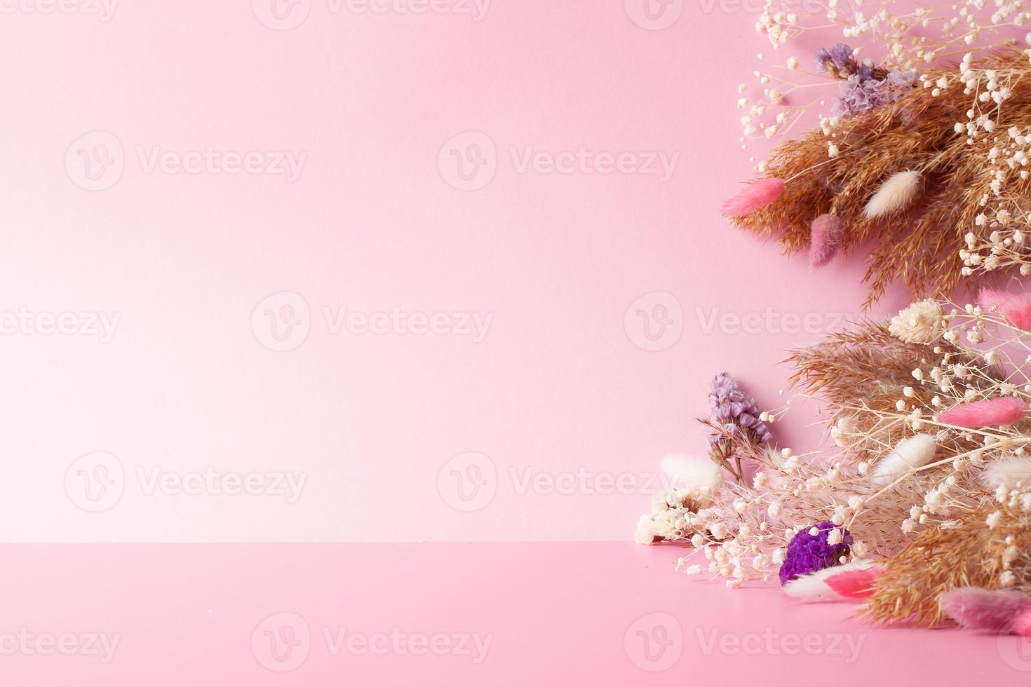 Cosmetic background with flowers and pampas on pink. Empty showcase for cosmetic product presentation. Copy space photo