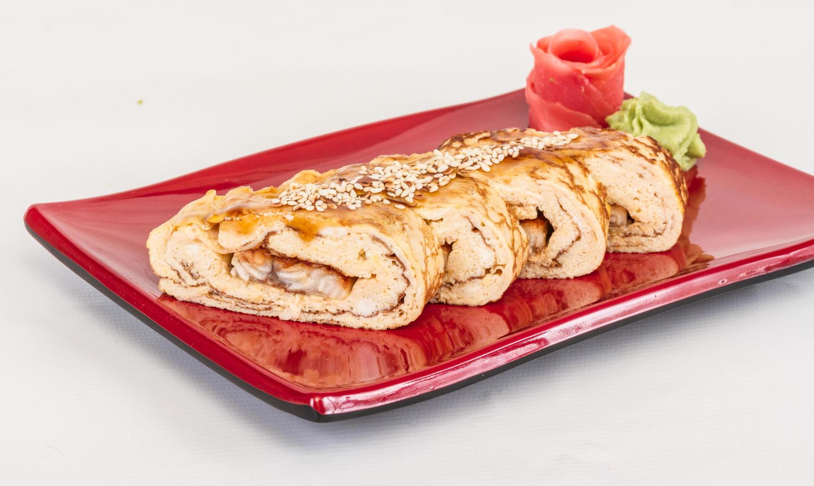 Omelet Maki Sushi - Roll made of Smoked Eel inside. Topped with Tamago and Sauce photo