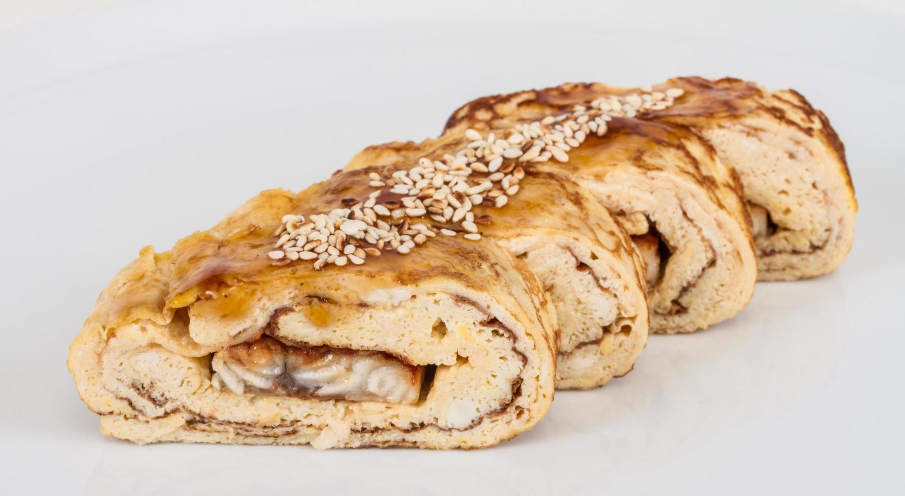 Omelet Maki Sushi - Roll made of Smoked Eel inside. Topped with Tamago and Sauce photo