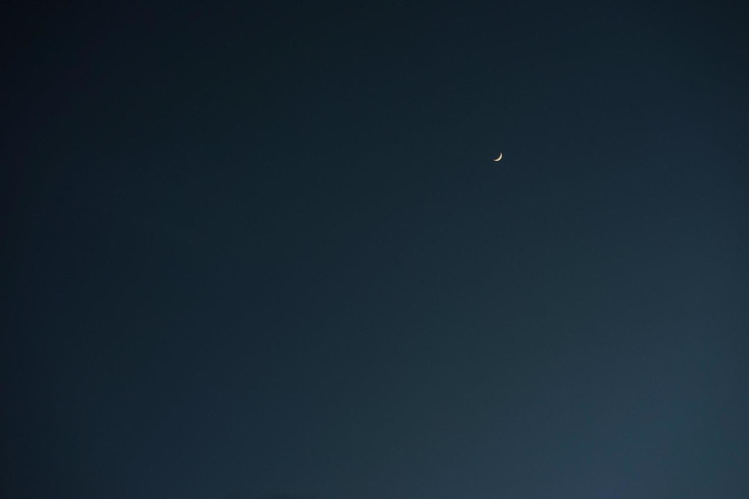 luna creciente con espacio de copia de cielo azul vacío para banner o fondo de papel tapiz foto