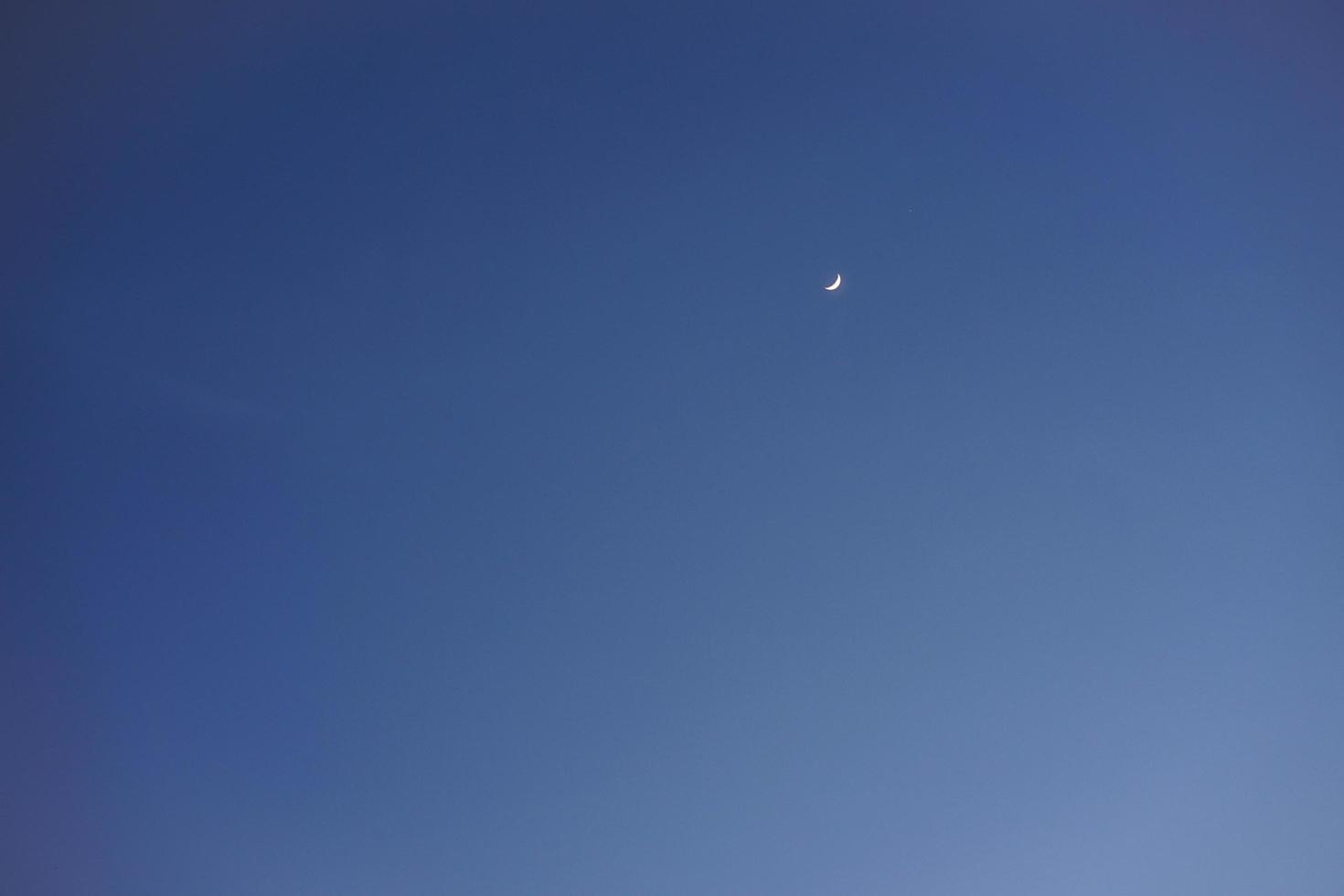 Crescent moon with empty blue sky copy space for banner or wallpaper background photo