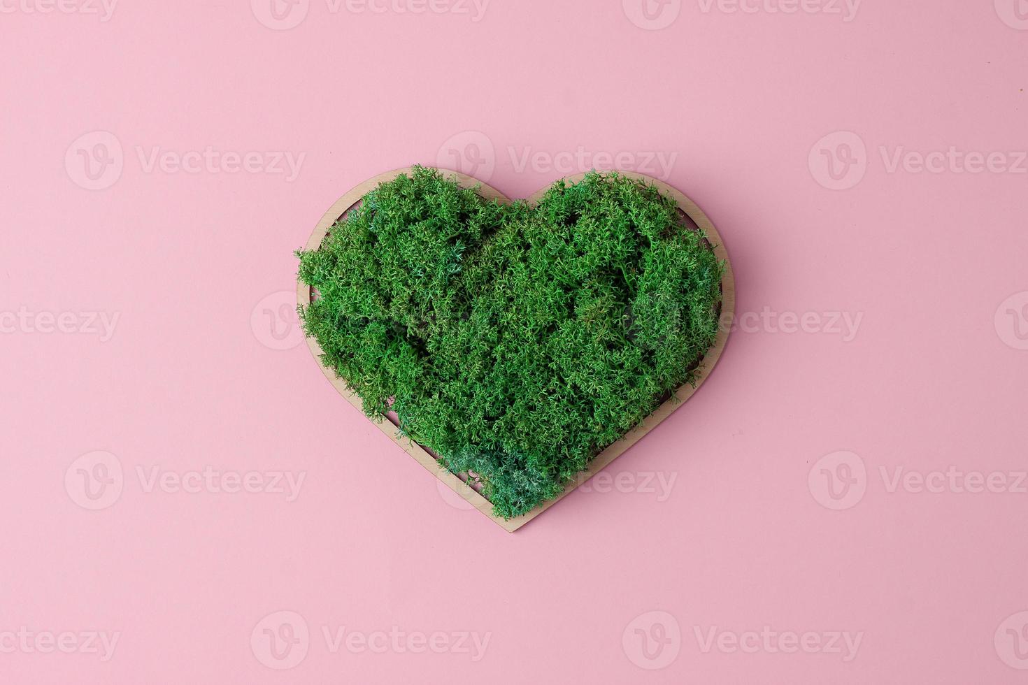 Cosmetic background with a wooden heart and moss on pink. Flat lay, copy space photo