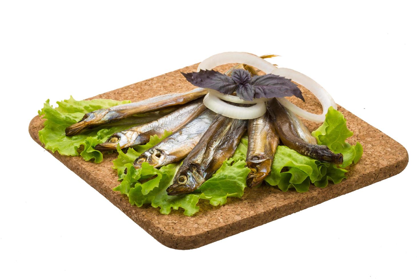 Dried Capelin on wooden board and white background photo