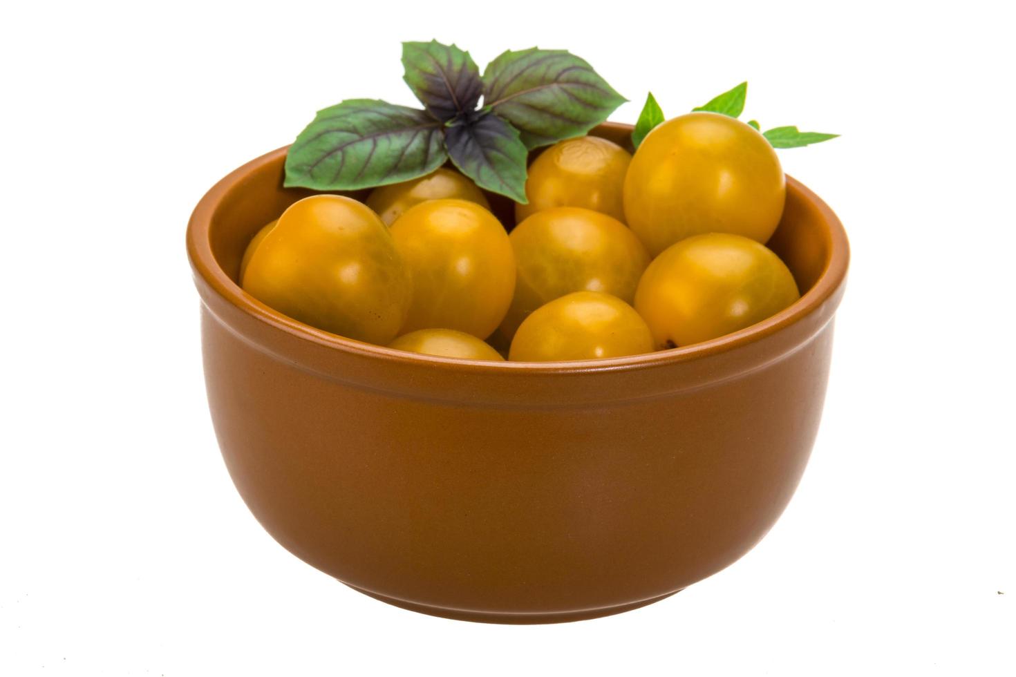 Yellow tomato in a bowl on white background photo