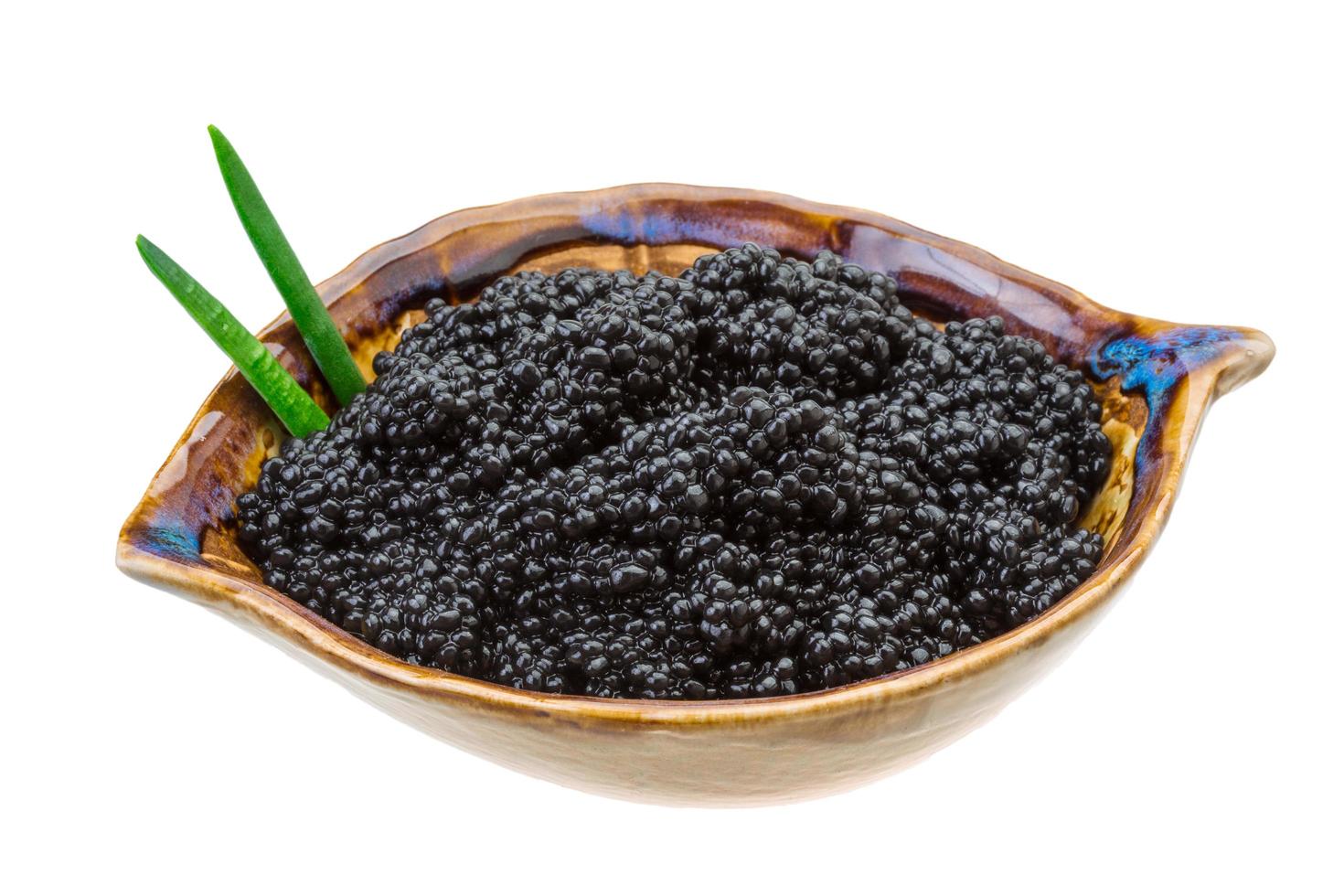 Black caviar in a bowl on white background photo