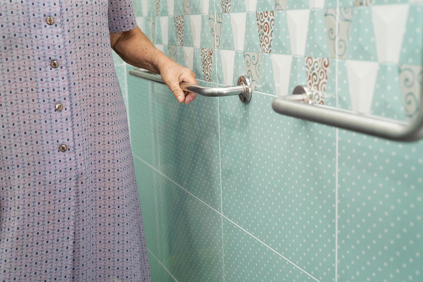 Asian senior or elderly old lady woman patient use toilet bathroom handle security in nursing hospital ward, healthy strong medical concept. photo
