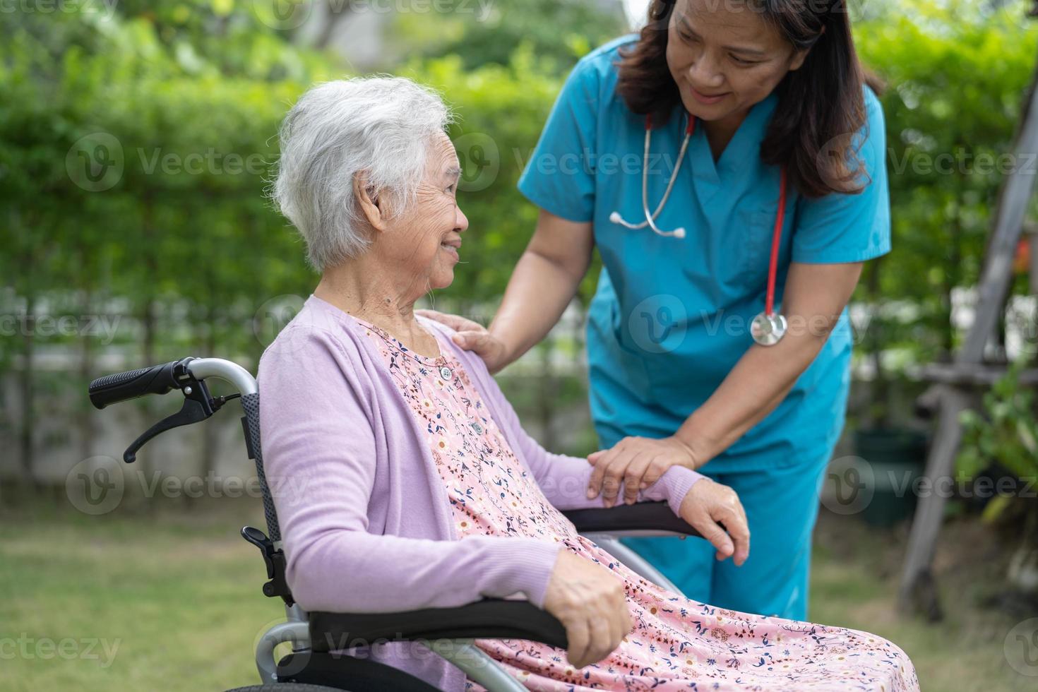 médico cuidador ayuda y cuida a una anciana asiática o anciana paciente sentada en silla de ruedas en la sala del hospital de enfermería, concepto médico fuerte y saludable foto