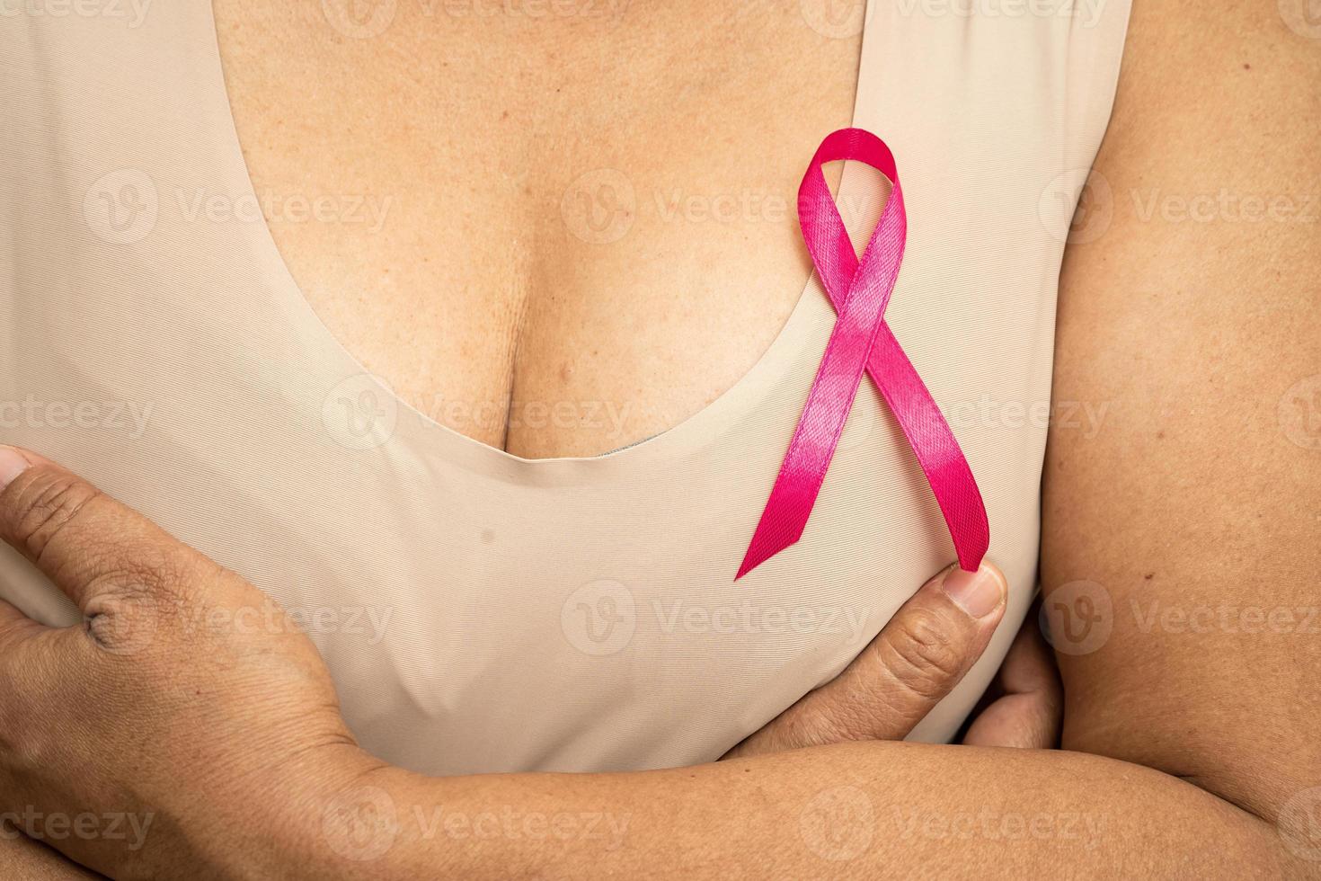 Breast cancer, pink ribbon at Asian senior lady for supporting awareness, symbol of World Breast Cancer Day. photo