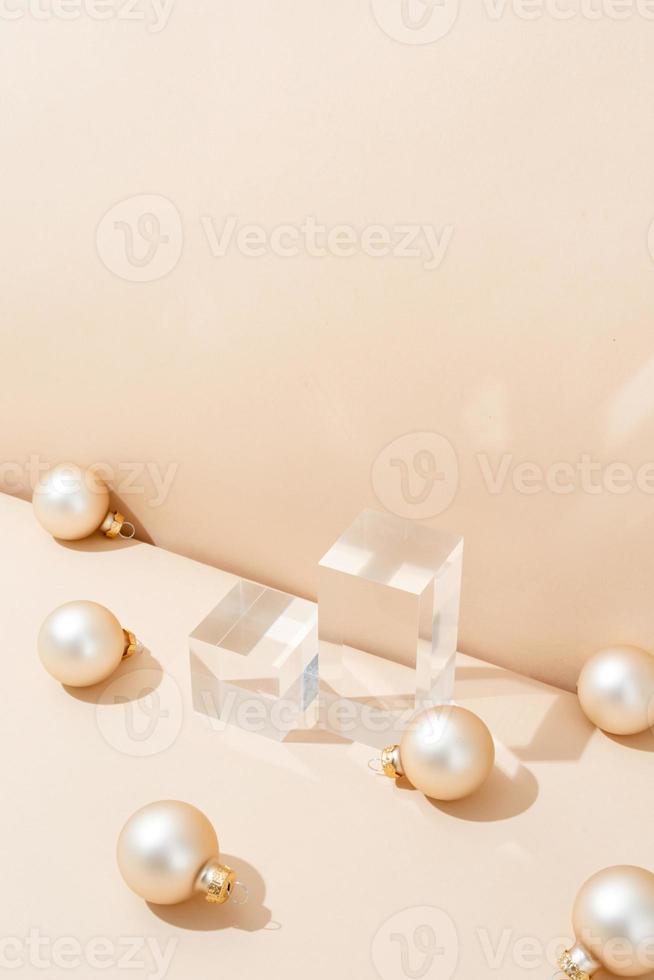 A minimalistic scene of glass podium with christmas pine tree and balls on beige background photo