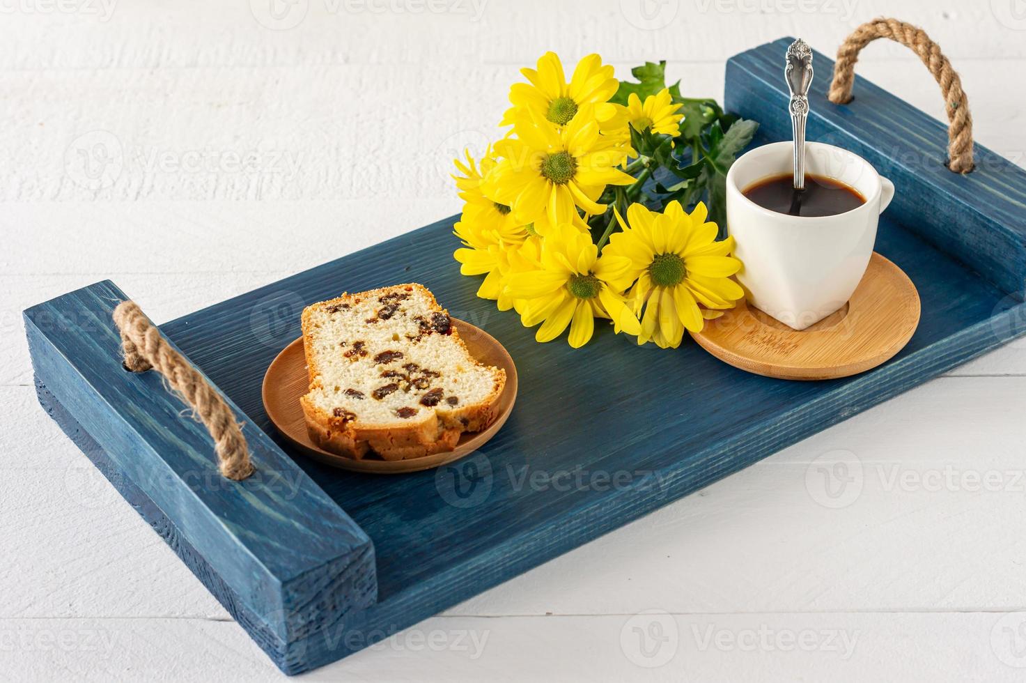 Slices of pound cake with raisins and a cup of coffee served on a tray. Morning tasty breakfast photo