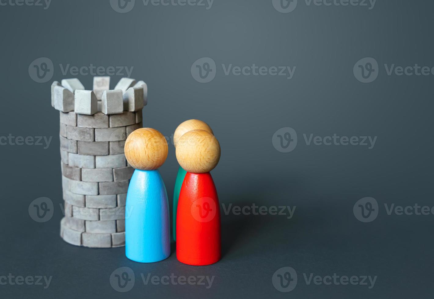 Medieval defense tower and people figurines. Safety, life and property insurance. Well protected. Security guard. Concept of resilience and strength. Durability, safety. Rights protection. photo