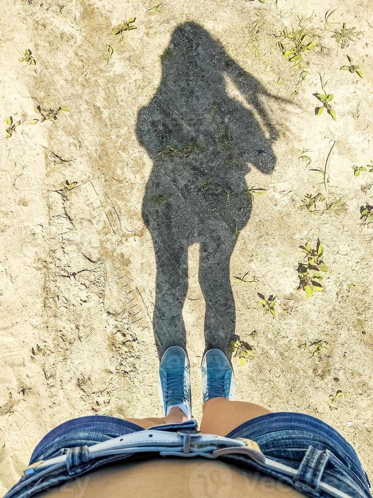 Shadow of young long-haired girl in sunny day photo