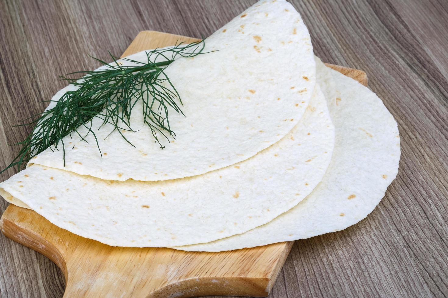 tortillas en tablero de madera y fondo de madera foto