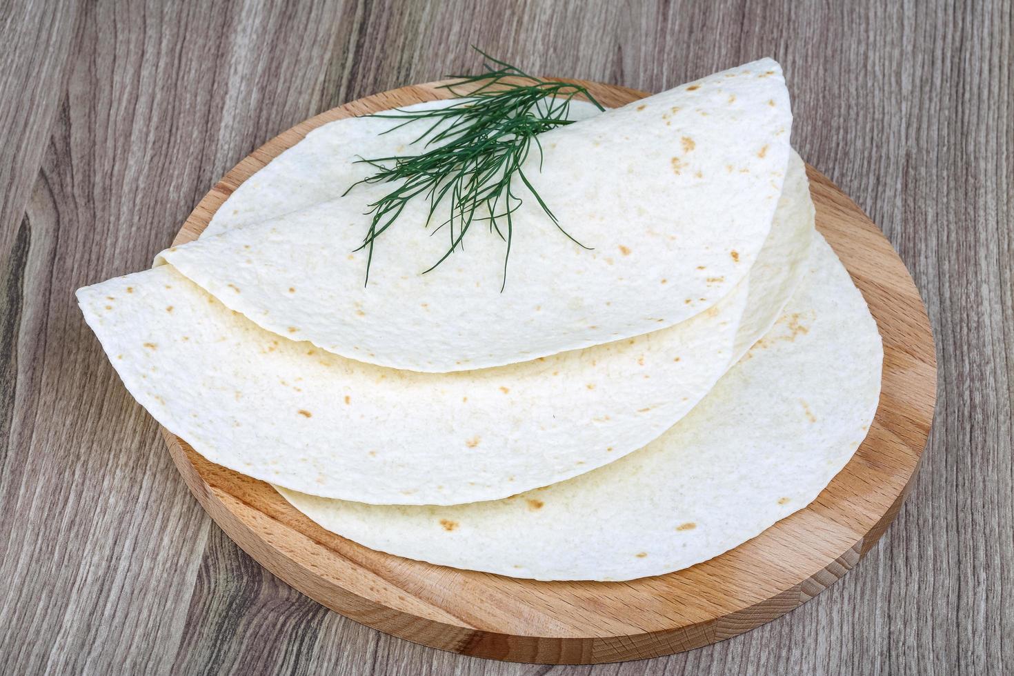 Tortillas on wooden board and wooden background photo