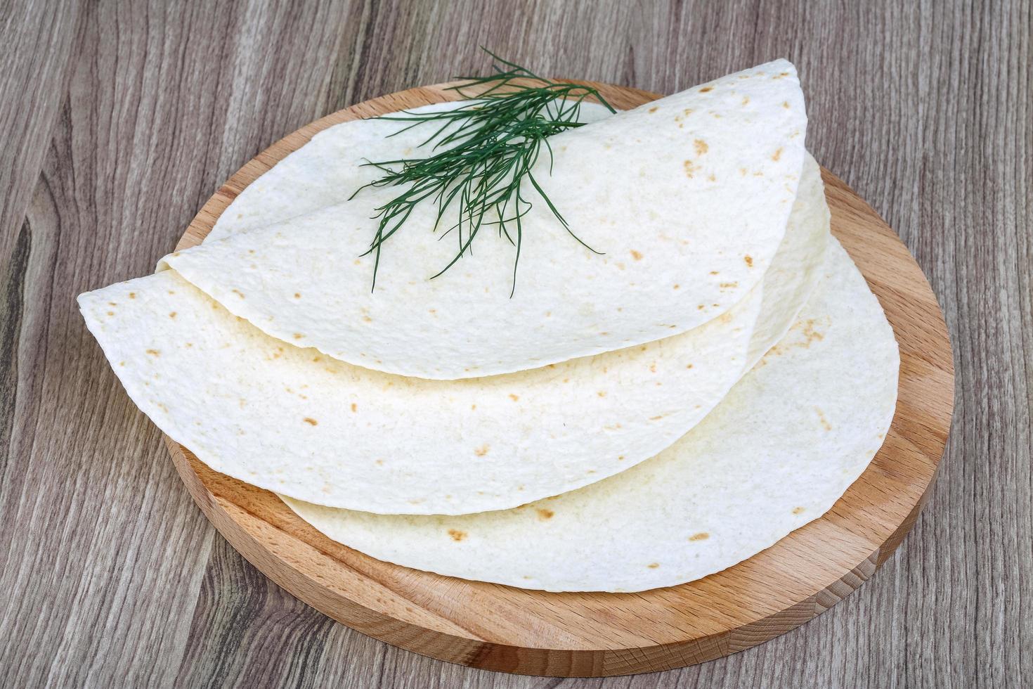 tortillas en tablero de madera y fondo de madera foto