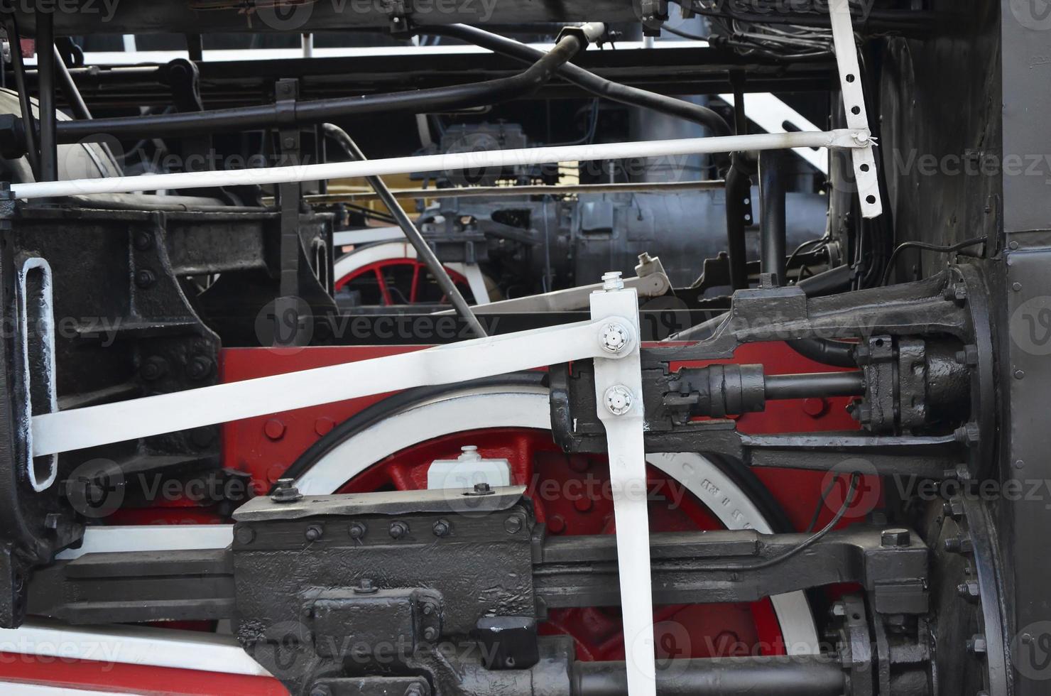 Wheels of the old black steam locomotive of Soviet times. The side of the locomotive with elements of the rotating technology of old trains photo